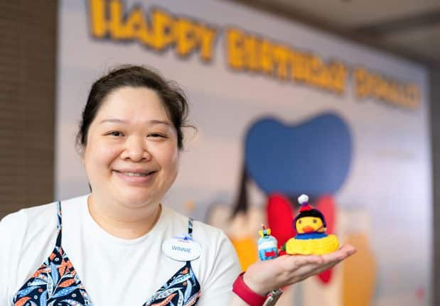 A Hong Kong Disneyland cast member poses with her duck