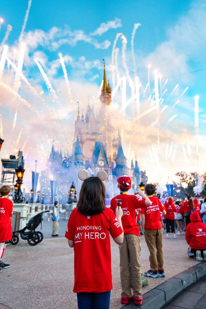 Families watch the magical cauldron in front of Cinderella Castle