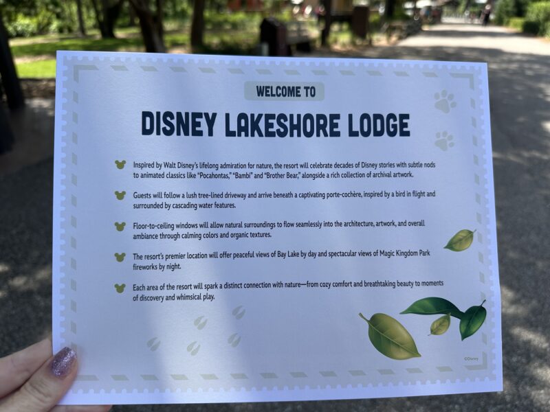 IMG1317 | The Main Street Mouse Sign reading Welcome to Disney Lakeshore Lodge with decorative border held outdoors in a park setting