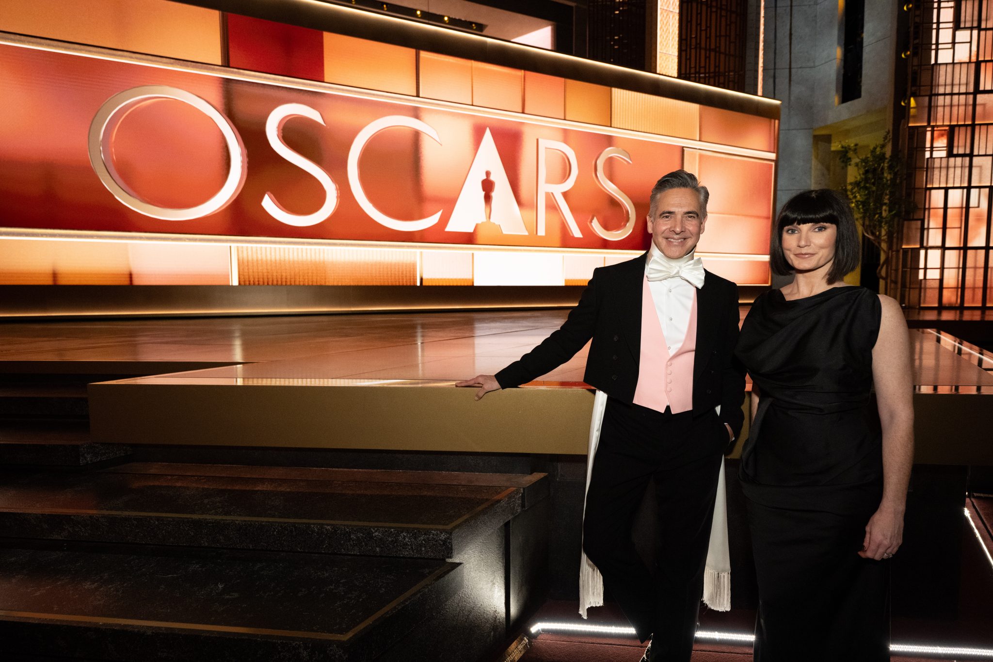 RajKapoorandKatyMullanCourtesyoftheAcademy2048x1365 | The Main Street Mouse Two Formally Dressed People Pose in Front of an Oscars Backdrop at a Red carpet style Event