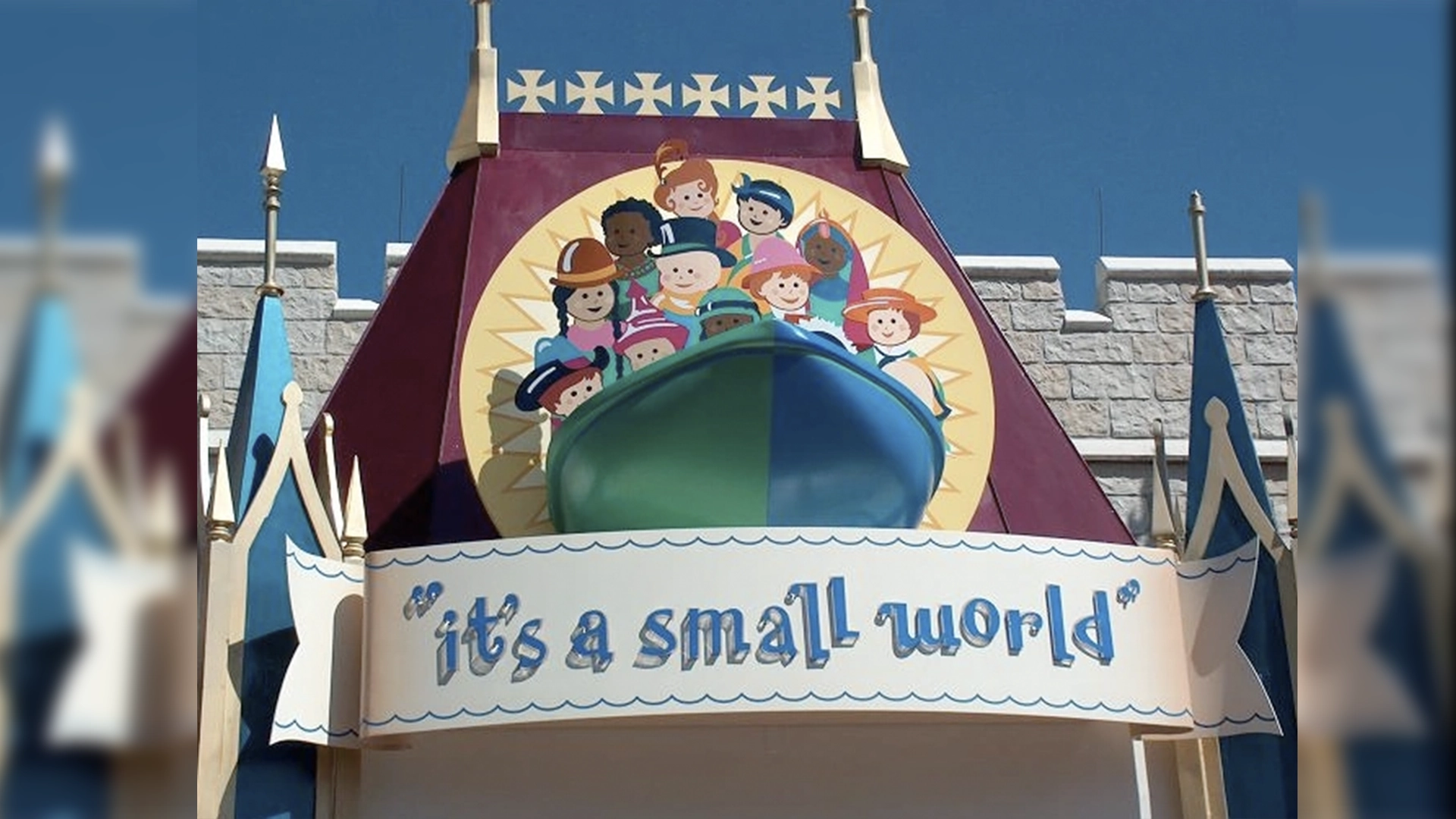 Facade of a Theme Park Ride with a Circle Mural of Diverse Children and the Words its a Small World